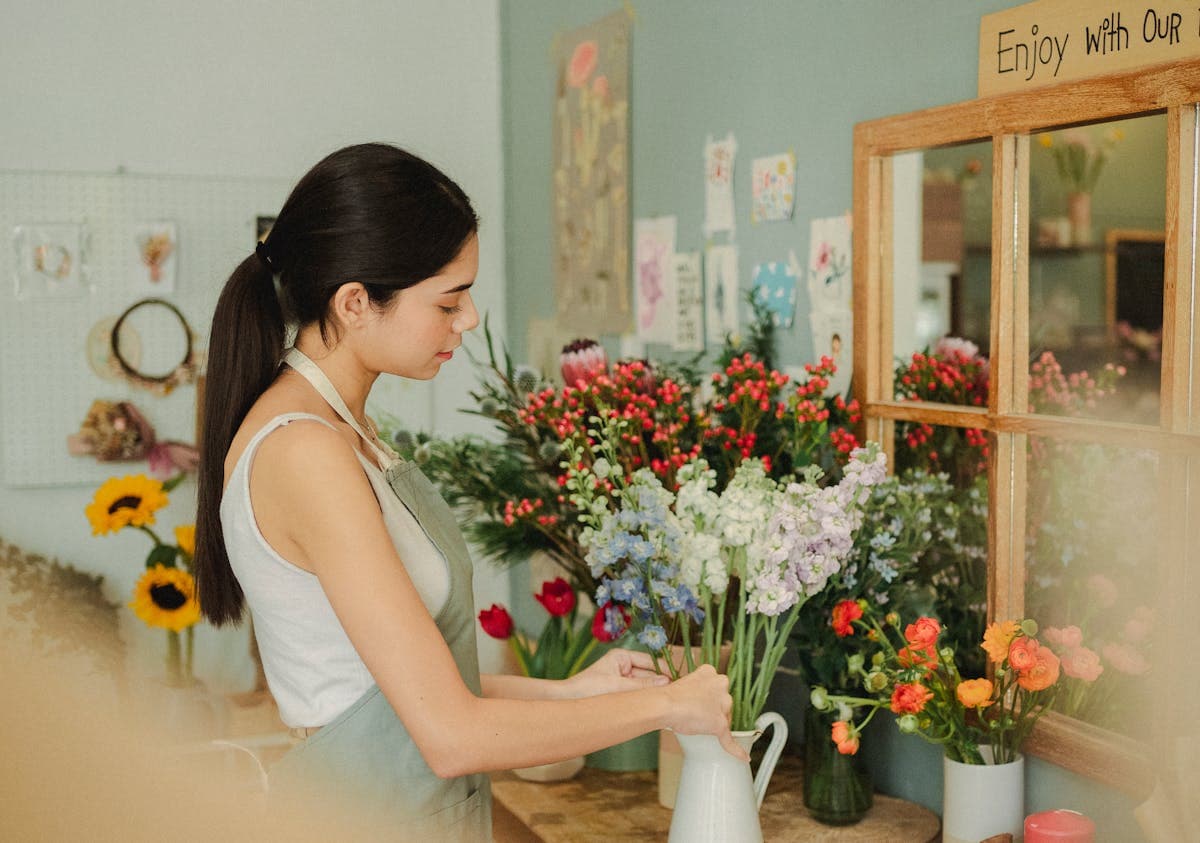 Independent florist arranging seasonal stems for a loyal regular